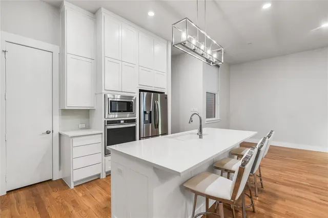 a kitchen with stainless steel appliances a kitchen island a stove a table and chairs