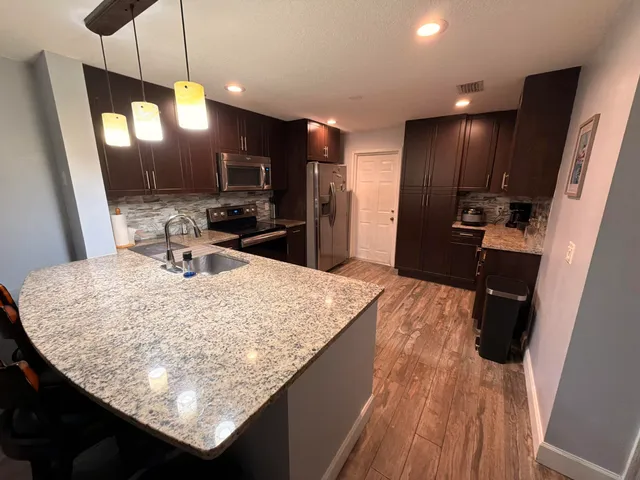a kitchen with kitchen island a sink stove and wooden floor