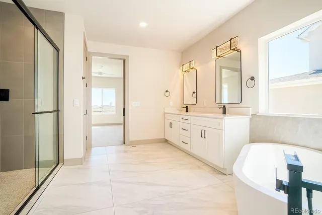 a spacious bathroom with a double vanity sink a mirror and a bathtub