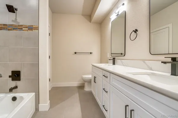 a bathroom with a tub sink and mirror