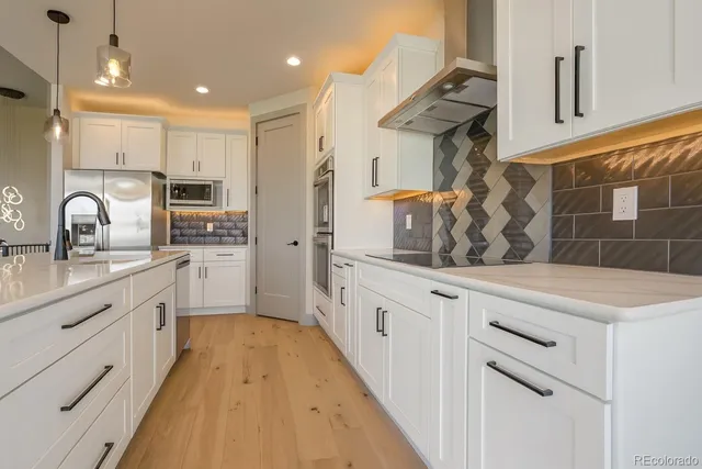 a kitchen with granite countertop white cabinets and white appliances