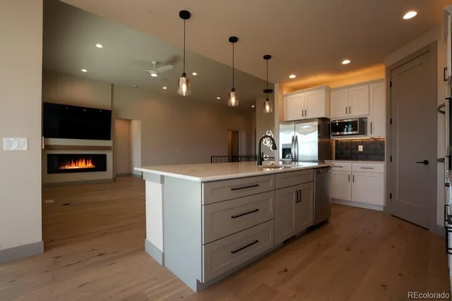 a kitchen with a refrigerator and a stove top oven