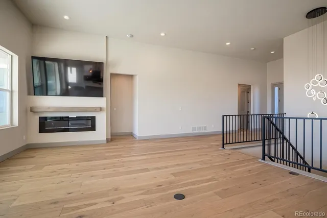 a view of an empty room with a fireplace and window