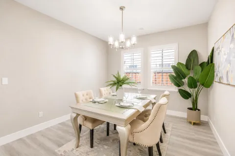 a dining room with furniture potted plants and wooden floor