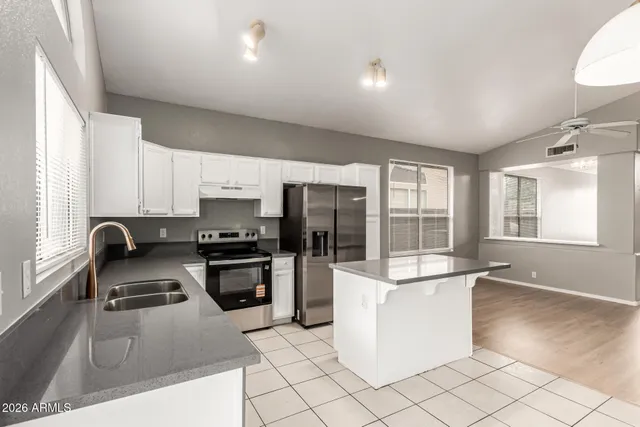 a kitchen with stainless steel appliances a stove a sink a refrigerator a window