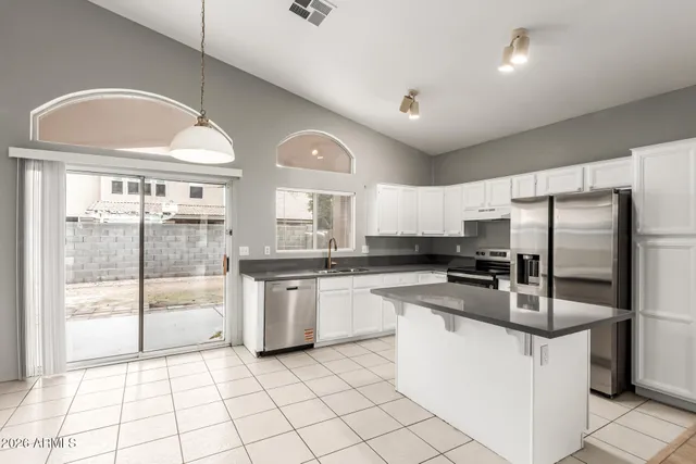 a kitchen with stainless steel appliances granite countertop a stove a sink and a refrigerator