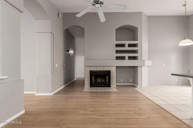 a view of a livingroom with a fireplace wooden floor and a window