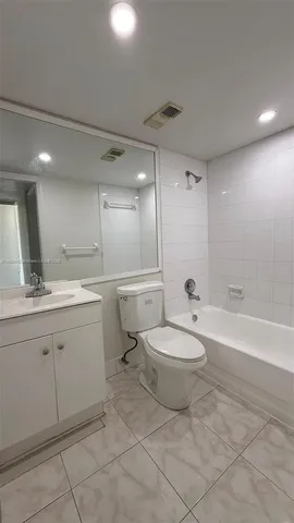 a bathroom with a toilet a sink a mirror and a bathtub