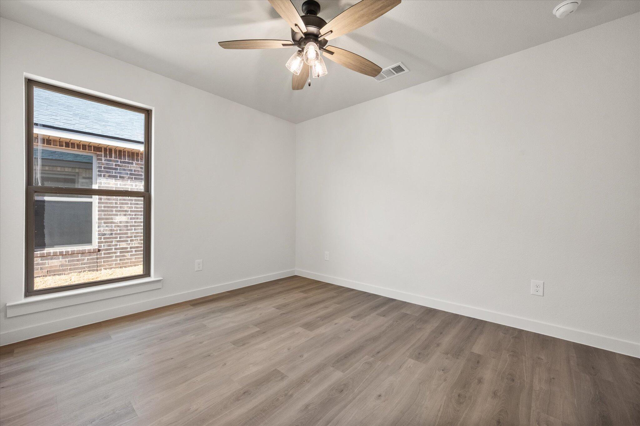 3108 138th Place Lubbock, TX 79423 - Photo 17 of 21 wooden floor in an empty room with a window