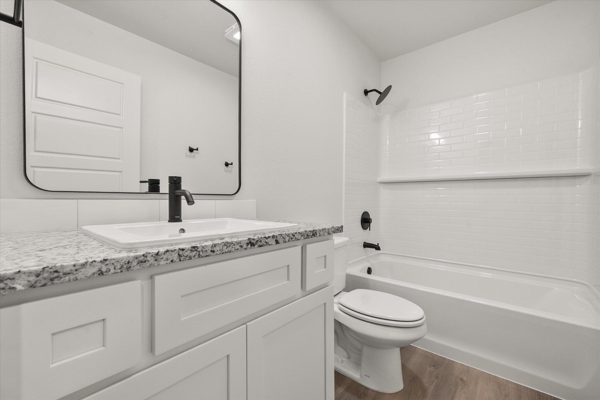 3108 138th Place Lubbock, TX 79423 - Photo 19 of 21 a bathroom with a granite countertop toilet sink and mirror
