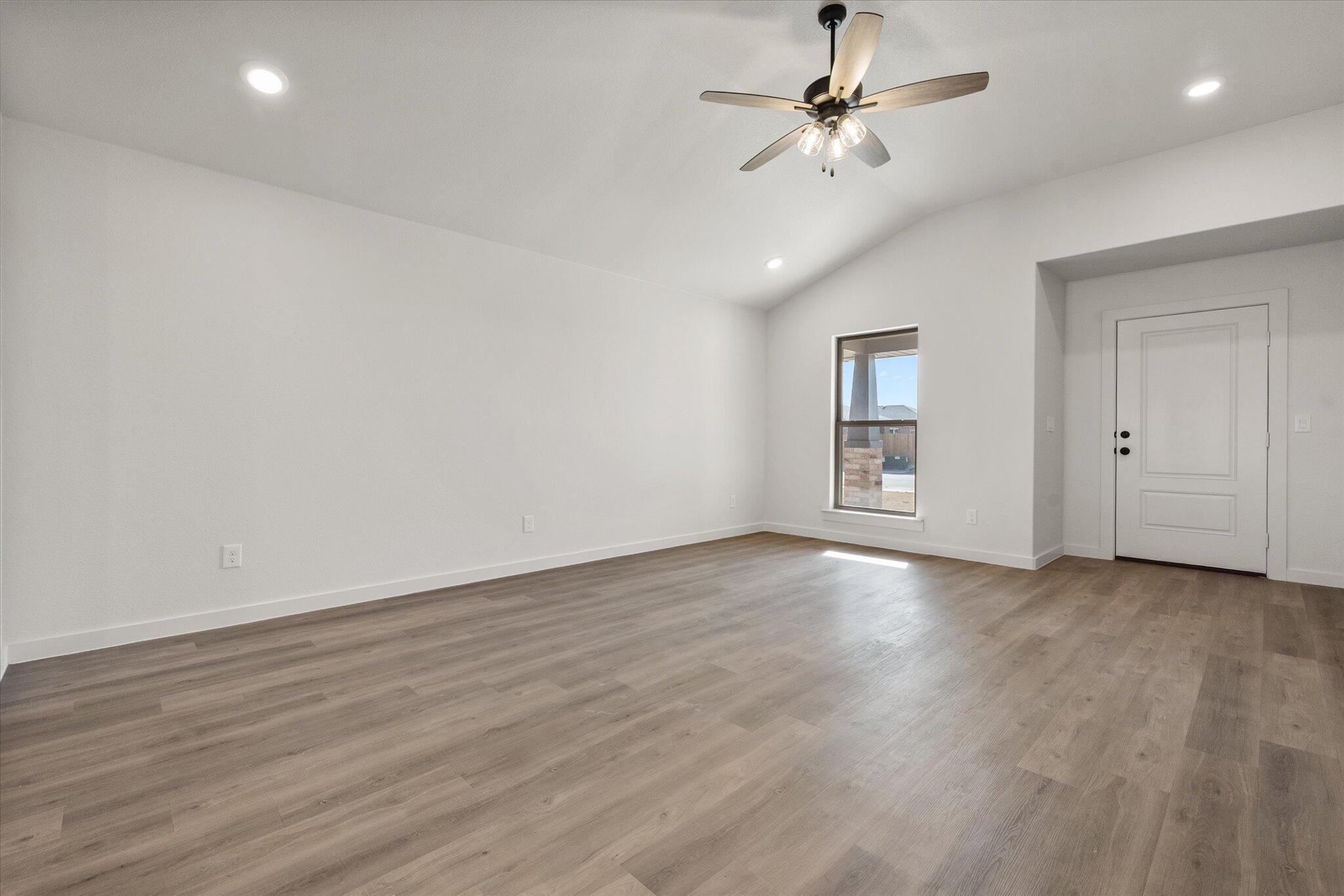 3108 138th Place Lubbock, TX 79423 - Photo 5 of 21 an empty room with wooden floor ceiling fan and windows