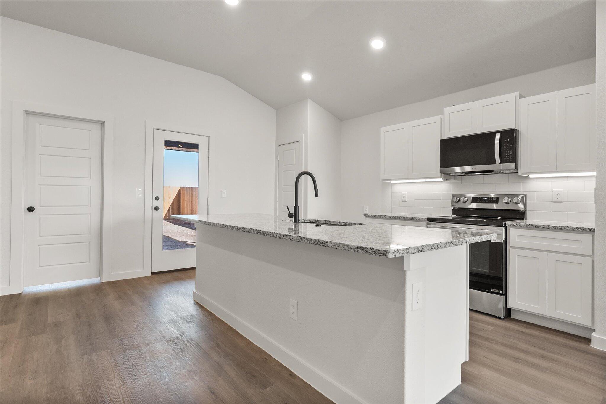 3108 138th Place Lubbock, TX 79423 - Photo 7 of 21 a kitchen with stainless steel appliances granite countertop a sink stove and microwave