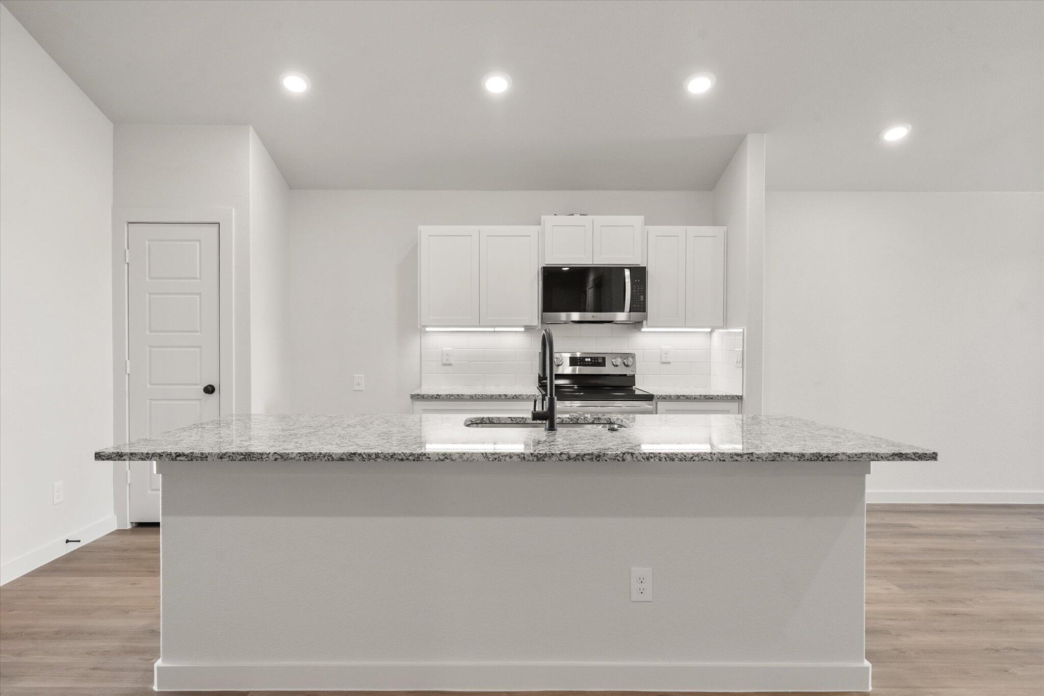 3108 138th Place Lubbock, TX 79423 - Photo 8 of 21 a kitchen with granite countertop a sink a stove and cabinets