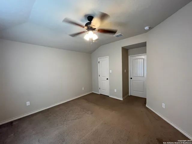 an empty room with a window and a fan