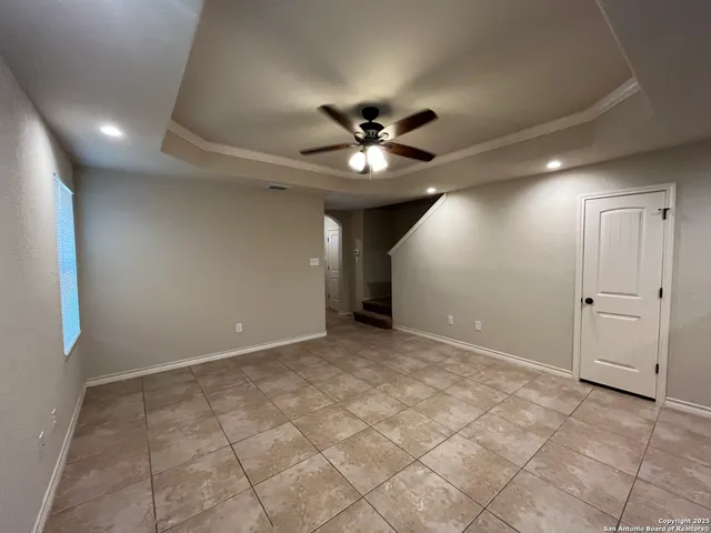 a view of a livingroom with a chandelier fan and a kitchen