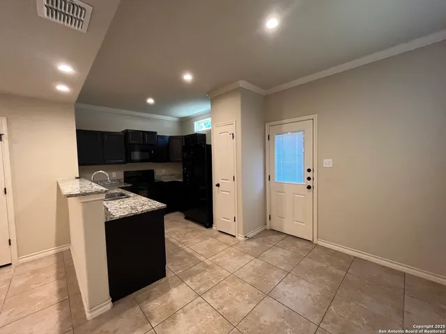 a open kitchen with stainless steel appliances granite countertop a refrigerator and a sink