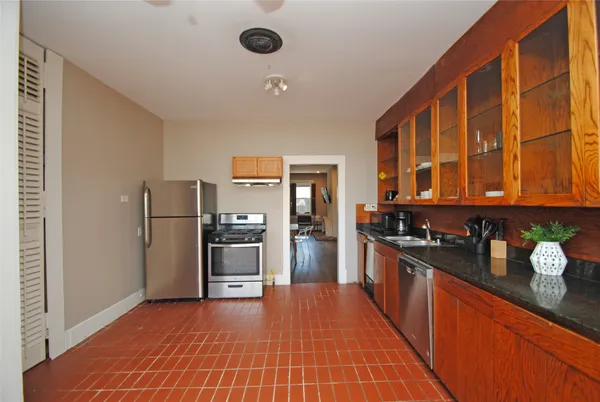 a kitchen with stainless steel appliances granite countertop a refrigerator and a stove top oven