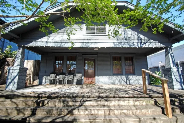 a view of a house with a tree bed and wooden fence