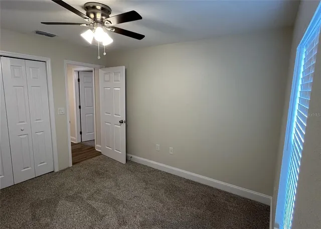an empty room with a ceiling fan and a fan