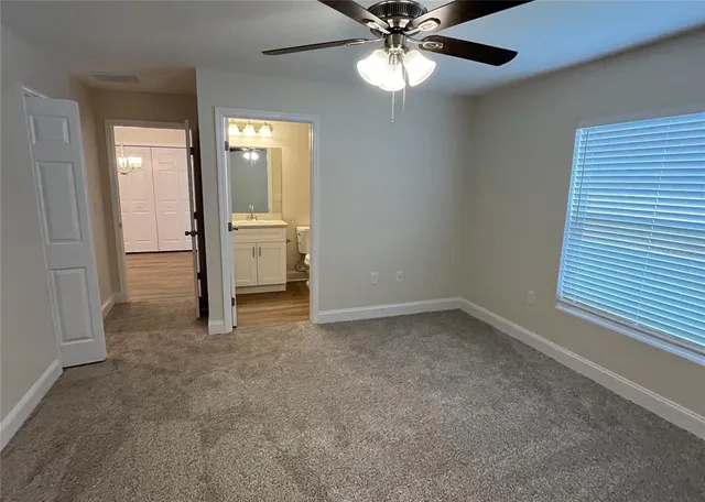 an empty room with closet and a chandelier fan