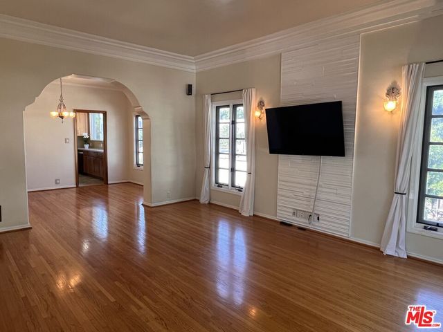 a view of a livingroom with wooden floor and a flat screen tv