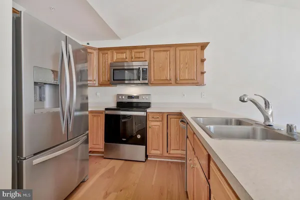 a kitchen with stainless steel appliances granite countertop a refrigerator stove and sink
