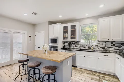 a kitchen with granite countertop a sink and cabinets
