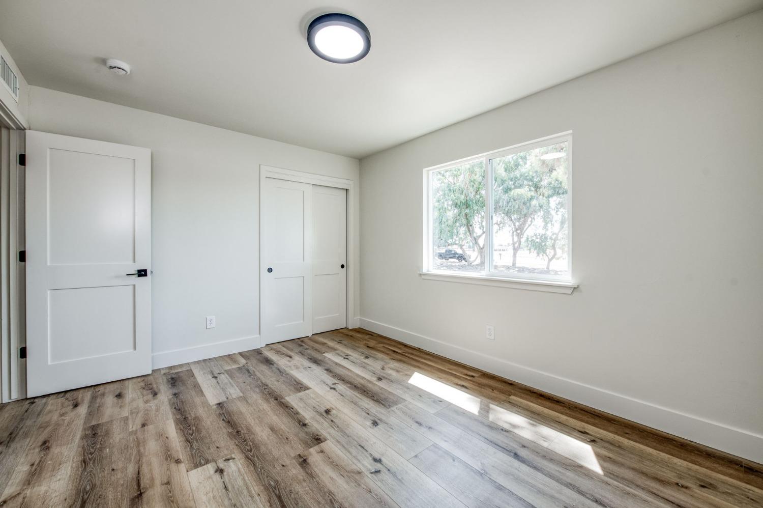 16715 Monreal Road Madera, CA 93636 - Photo 14 of 39 wooden floor in an empty room with a window