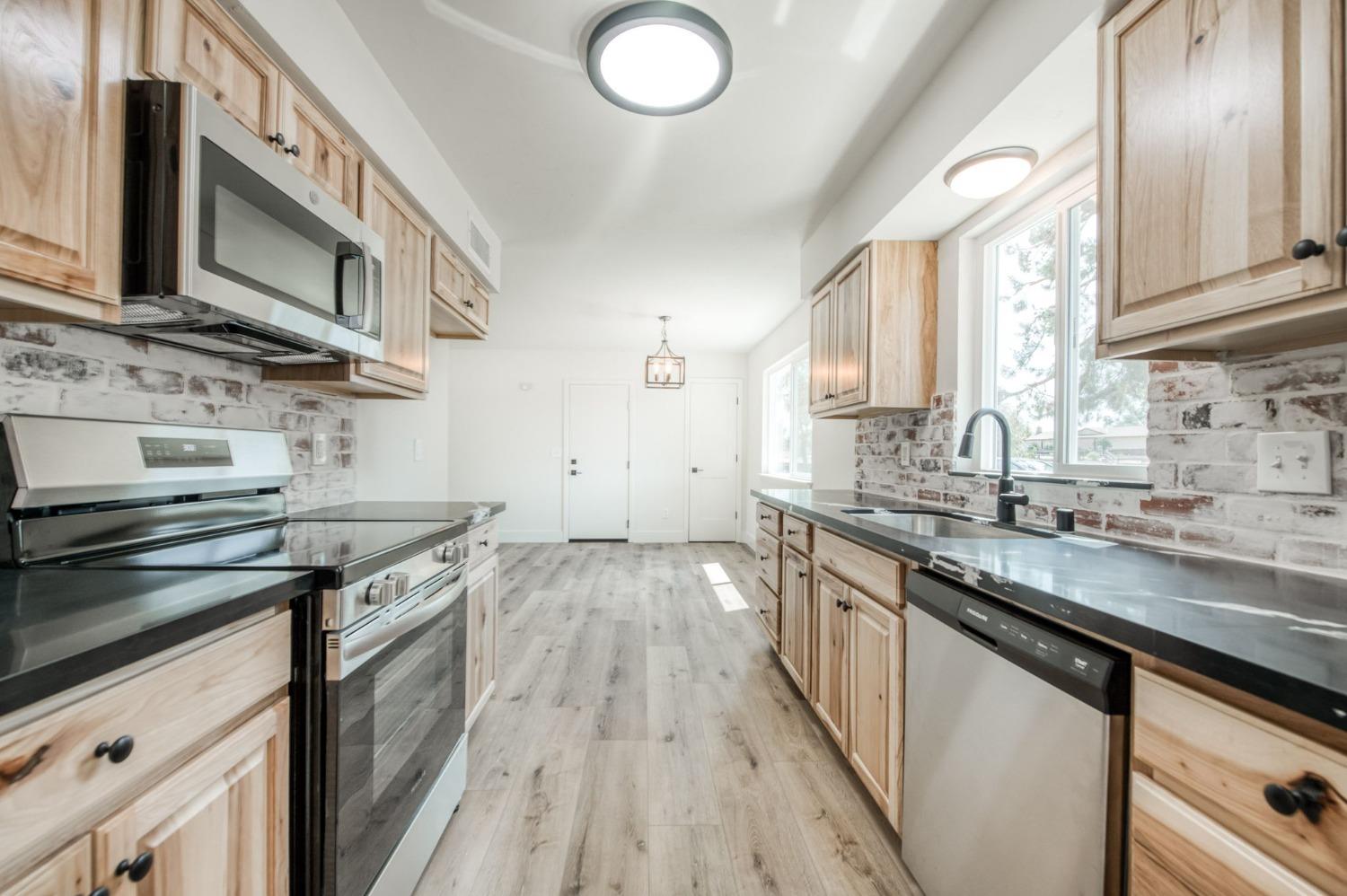 16715 Monreal Road Madera, CA 93636 - Photo 15 of 39 a kitchen with stainless steel appliances granite countertop a stove and a sink
