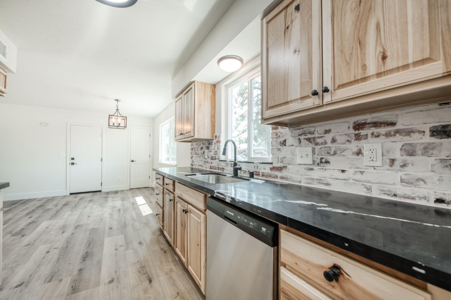 16715 Monreal Road Madera, CA 93636 - Photo 17 of 39 a kitchen with granite countertop a sink a stove and cabinets