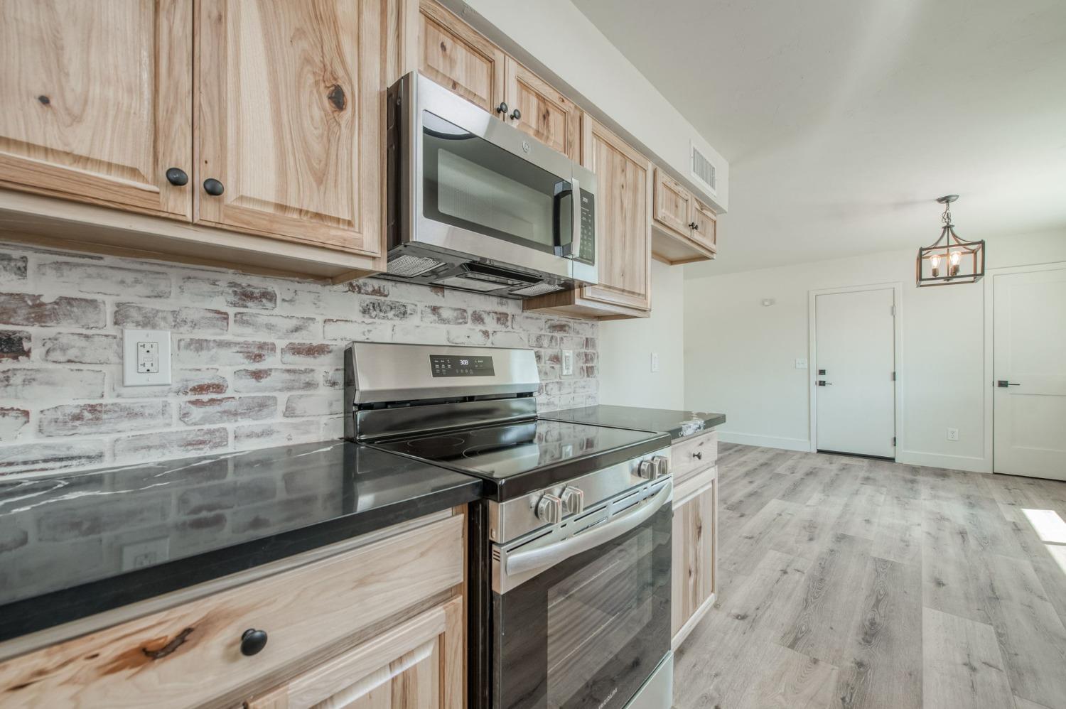 16715 Monreal Road Madera, CA 93636 - Photo 2 of 39 a kitchen with stainless steel appliances granite countertop a stove and a microwave