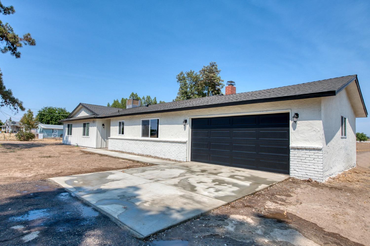 16715 Monreal Road Madera, CA 93636 - Photo 25 of 39 a front view of a house with a yard and garage