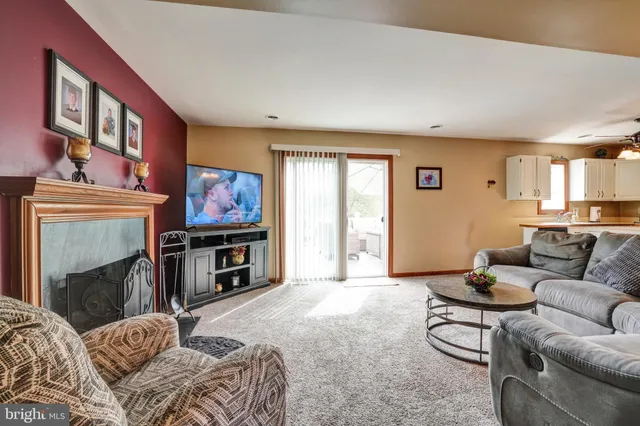 a living room with furniture a flat screen tv and a fireplace