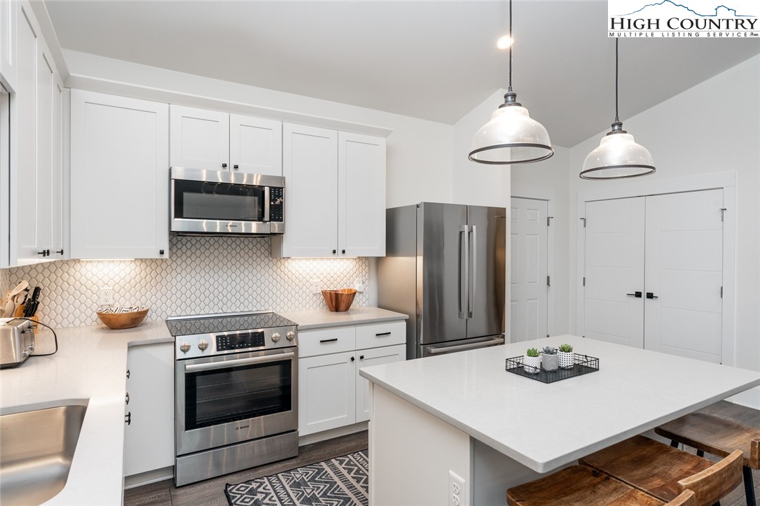 1150 Main Street, Unit DOGWOOD Blowing Rock, NC 28605 - Photo 11 of 26 a kitchen with stainless steel appliances a stove a sink a refrigerator and cabinets