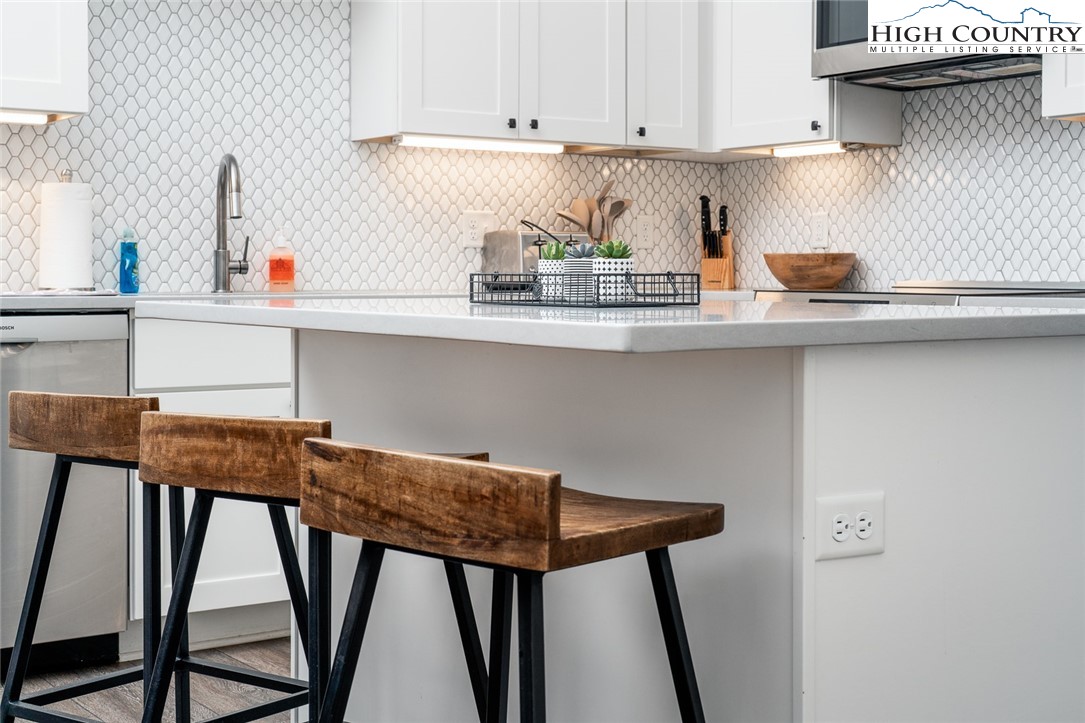 1150 Main Street, Unit DOGWOOD Blowing Rock, NC 28605 - Photo 12 of 26 a kitchen with a wooden table and cabinets