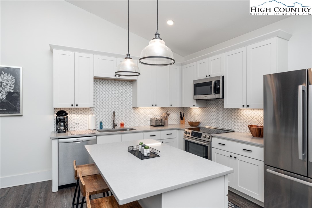 1150 Main Street, Unit DOGWOOD Blowing Rock, NC 28605 - Photo 10 of 26 a kitchen with kitchen island a white cabinets and refrigerator