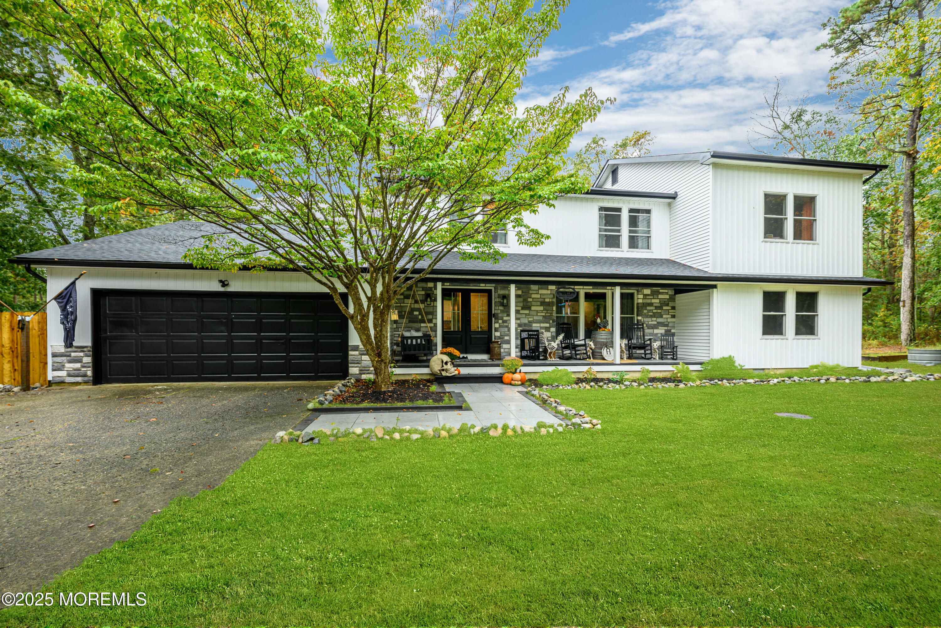 a front view of a house with a yard and trees