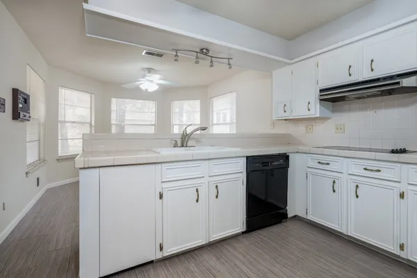 a kitchen with granite countertop white cabinets and white appliances