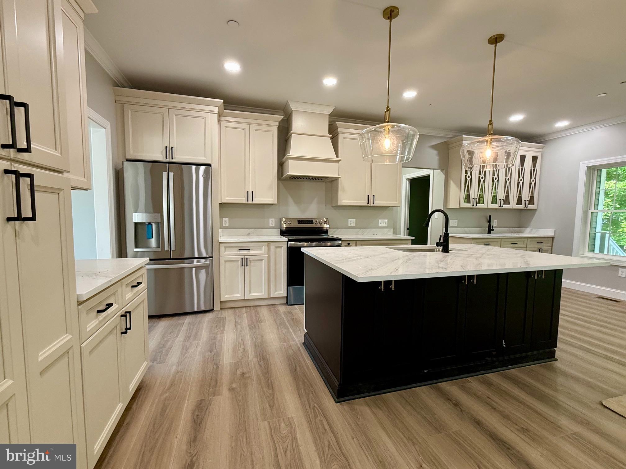 17480 Lighthouse Commons Drive Piney Point, MD 20674 - Photo 9 of 23 a kitchen with kitchen island granite countertop a sink refrigerator and cabinets