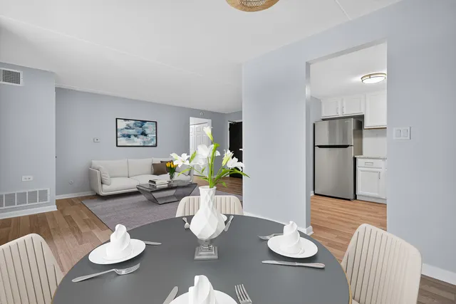 an empty room with wooden floor and a refrigerator