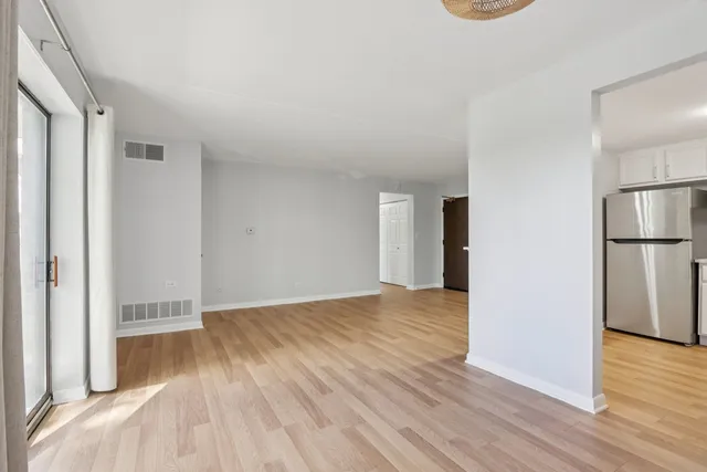 an empty room with wooden floor and sliding door