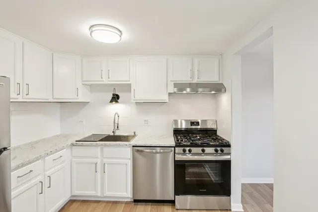 a kitchen with a refrigerator sink and cabinets