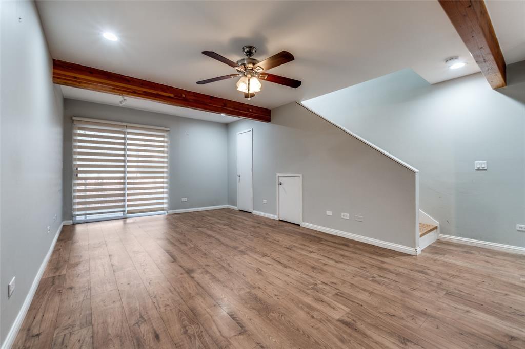 4231 Travis Street, Unit 20 Dallas, TX 75205 - Photo 2 of 23 a view of an empty room with wooden floor and a ceiling fan
