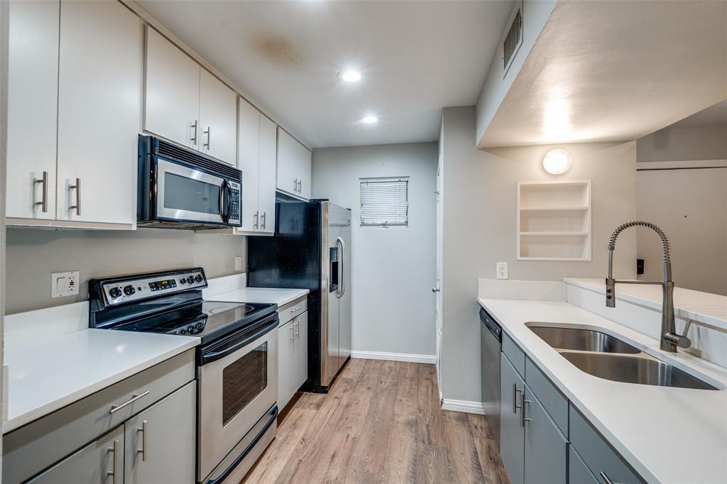 4231 Travis Street, Unit 20 Dallas, TX 75205 - Photo 10 of 23 a kitchen with stainless steel appliances granite countertop a sink a stove a refrigerator cabinets and a wooden floor