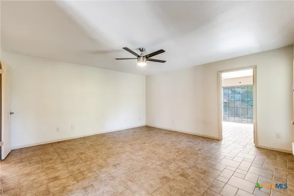 a view of a livingroom with a chandelier fan and windows