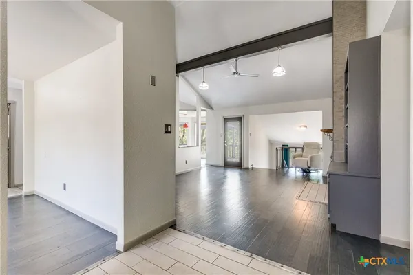 a view of a big room with wooden floor and windows