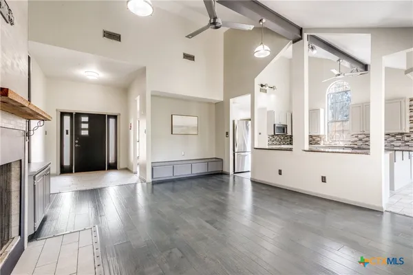 a large white kitchen with a large window and stainless steel appliances