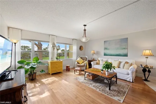 a living room with furniture a wooden floor and a chandelier
