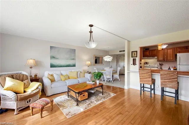 a living room with furniture a chandelier and a flat screen tv