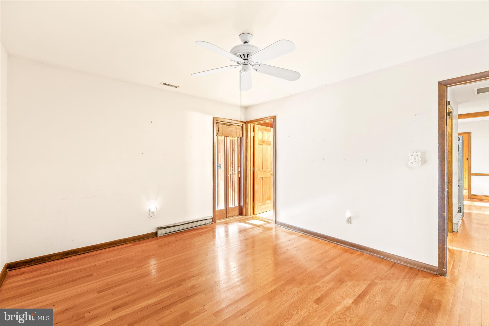 4170 Coulbourn Mill Road Salisbury, MD 21804 - Photo 27 of 47 an empty room with wooden floor chandelier fan and windows